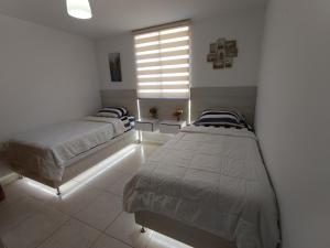 a bedroom with two beds and a window at Confortable apartamento en Marina del Rey Lecheria in El Morro de Barcelona +2 photos