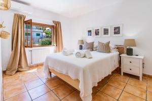 a bedroom with a large white bed and a window at Ca Ne Margalide by Mallorca Infinity in Port d’Andratx