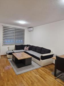 トゥズラにあるApartman 3 Tuzlaのソファとテーブルのあるリビングルーム