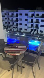 a table and chairs in a room with a pool at Rmilat Garden N8 vue sur la piscine in Cabo Negro