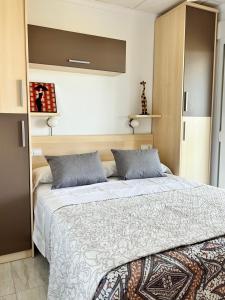 a bedroom with a large bed with blue pillows at Apartamento NEPTUNO PLAYA in Peniscola +29 photos