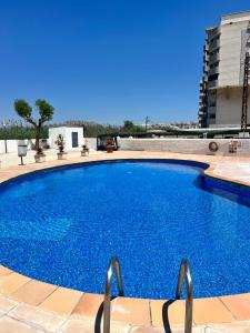 een groot blauw zwembad bovenop een gebouw bij Apartamento NEPTUNO PLAYA in Peñíscola