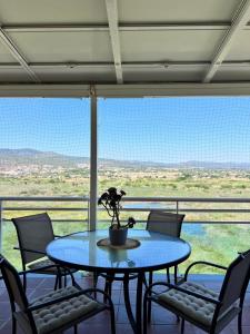 een tafel en stoelen voor een groot raam bij Apartamento NEPTUNO PLAYA in Peñíscola