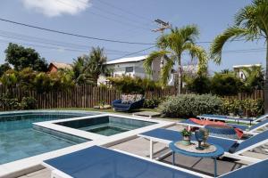 a swimming pool with two chairs and a table and a swimming pool at casa de guarajuba in Camacari +14 photos