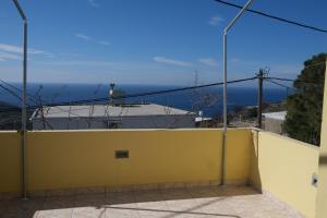 a yellow wall with a view of the ocean at O Milos in Sidiroúnta