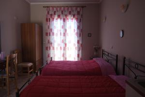 a bedroom with two beds and a window at O Milos in Sidiroúnta