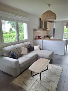 a living room with a couch and a table at Maison 5 personnes in Lutterbach +3 photos