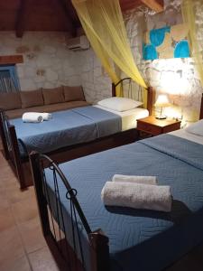 Postel nebo postele na pokoji v ubytování Lithos stone house (Ionio holidays)