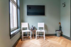 two white chairs and a table in a room at Suite Palette in Amsterdam