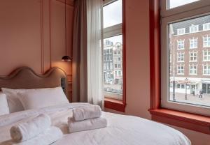 アムステルダムにあるSuite Paletteのベッドと大きな窓のある寝室