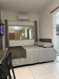 a bedroom with a bed and a large window at Flat Adenil Falcão - By Temporada Expert -Moderno e Próximo ao centro in Feira de Santana