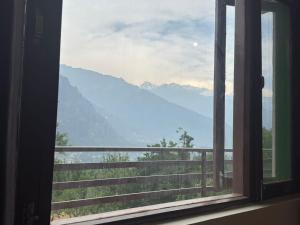 マナリにあるPeaceful Village Stayの山の景色を望む窓