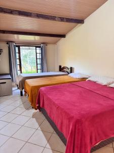 two beds sitting next to each other in a room at Chalé Bella Vista in Guaramiranga