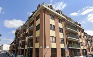 a tall building with cars parked in front of it at Spacious 2-Bedroom Apartment with Large Terrace in Milan