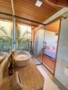 a bathroom with a large tub and a bedroom at Sítio Morro do Balaio in Guarapari +34 photos