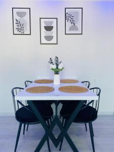 ダラマンにあるComfortable, stylish, centrally located apartmentの白いテーブルと椅子、花瓶