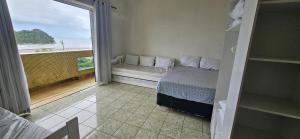 een slaapkamer met een bed en uitzicht op de oceaan bij Vista incrível para o mar! in Santos