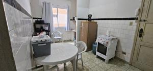 een kleine keuken met een kleine tafel en een kleine koelkast bij Vista incrível para o mar! in Santos