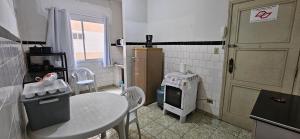 een keuken met een tafel, een tafel en een deur bij Vista incrível para o mar! in Santos +21 foto's