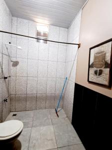 a bathroom with a shower with a toilet and a mop at Casa em Soure Ilha de Marajó. in Soure