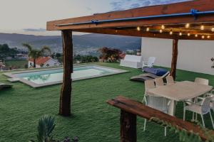 un patio avec une table et des chaises et une piscine dans l'établissement Villa Cantinho da Cavadinha, à Arouca