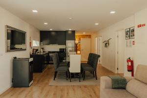 une cuisine et un salon avec une table et des chaises dans l'établissement Villa Cantinho da Cavadinha, à Arouca