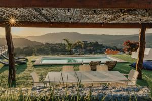 - une table et des chaises dans une cour avec une piscine dans l'établissement Villa Cantinho da Cavadinha, à Arouca