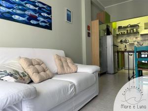 ein weißes Sofa in einem Wohnzimmer mit Küche in der Unterkunft Casa vacanze - Mare e Luna in Montesilvano