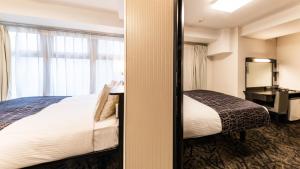 a hotel room with a bed and a window at APA Hotel Nambaminami Daikokucho Ekimae in Osaka
