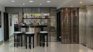 a bar in the middle of a room with stools at Hotel Corbel Superior by bund in Mar del Plata