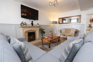 a living room with a white couch and a fireplace at Cottage nr BikeParkWales/Brecon Beacons/PenYFan in Merthyr Tydfil