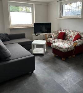 a living room with two couches and a tv at Gemütliches Appartement in Bad Rothenfelde in Bad Rothenfelde