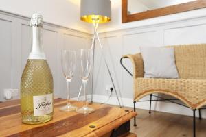 a bottle of champagne and two wine glasses on a table at Cottage nr BikeParkWales/Brecon Beacons/PenYFan in Merthyr Tydfil