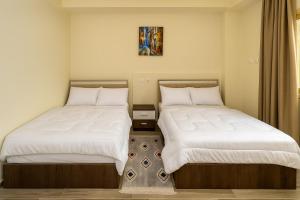 two beds sitting next to each other in a room at CK. 209 . Spacious 2BR Apt. 2 BA Gated Community in Sheikh Zayed +28 photos