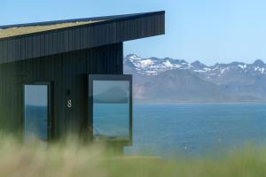 um edifício com vista para a água e as montanhas em Peninsula Suites em Hellnar