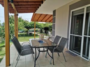 a dining table and chairs on a patio at Villa Sophie in Orfánion