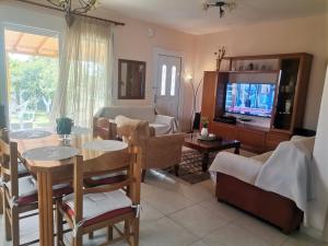 a living room with a table and a tv at Villa Sophie in Orfánion