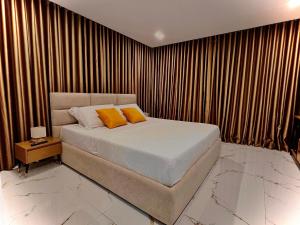 a bed with two orange pillows in a bedroom at Dine Hotel in Ksamil