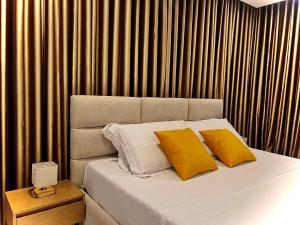 a bedroom with a bed with two yellow pillows at Dine Hotel in Ksamil