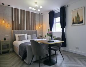 a bedroom with a bed and a table with chairs at Shoreditch Luxe in London