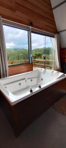 a large bath tub in a room with a window at Cabana Santa Cruz 2 in São Francisco de Paula +37 photos