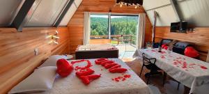 a room with two beds and a table with red pillows at Cabana Santa Cruz 2 in São Francisco de Paula