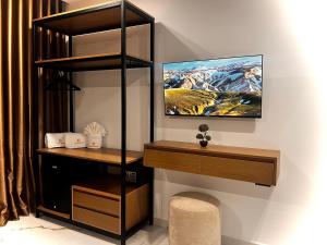 a room with a shelf and a tv on a wall at Dine Hotel in Ksamil