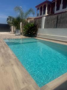 una grande piscina blu davanti a una casa di Tropical Garden Home - Cozy Ground Floor Stay a San Pedro del Pinatar Altre 8 foto