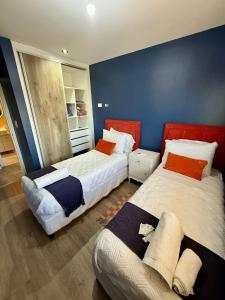 two beds in a room with blue walls at Departamento con Vista al Río in Posadas