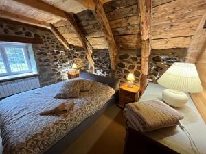 a bedroom with a bed in a room with wooden walls at La Grangette de Barbe in Le Béage