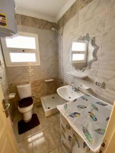 a bathroom with a toilet and a sink at Cairo Madinty 2 in Madinaty +1 photo