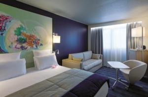 a hotel room with a bed and a chair at Mercure Toulouse Centre Saint-Georges in Toulouse