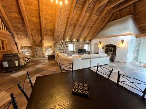 a large living room with a wooden ceiling and a table at La Grangette de Barbe in Le Béage
