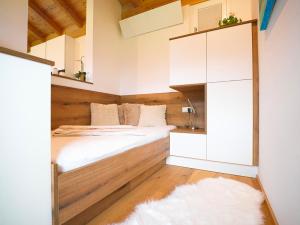 une petite chambre avec un lit et un miroir dans l'établissement Tyrolchalet LITTLE LUCK - AlpenLuxus Collection, à Rofansiedlung